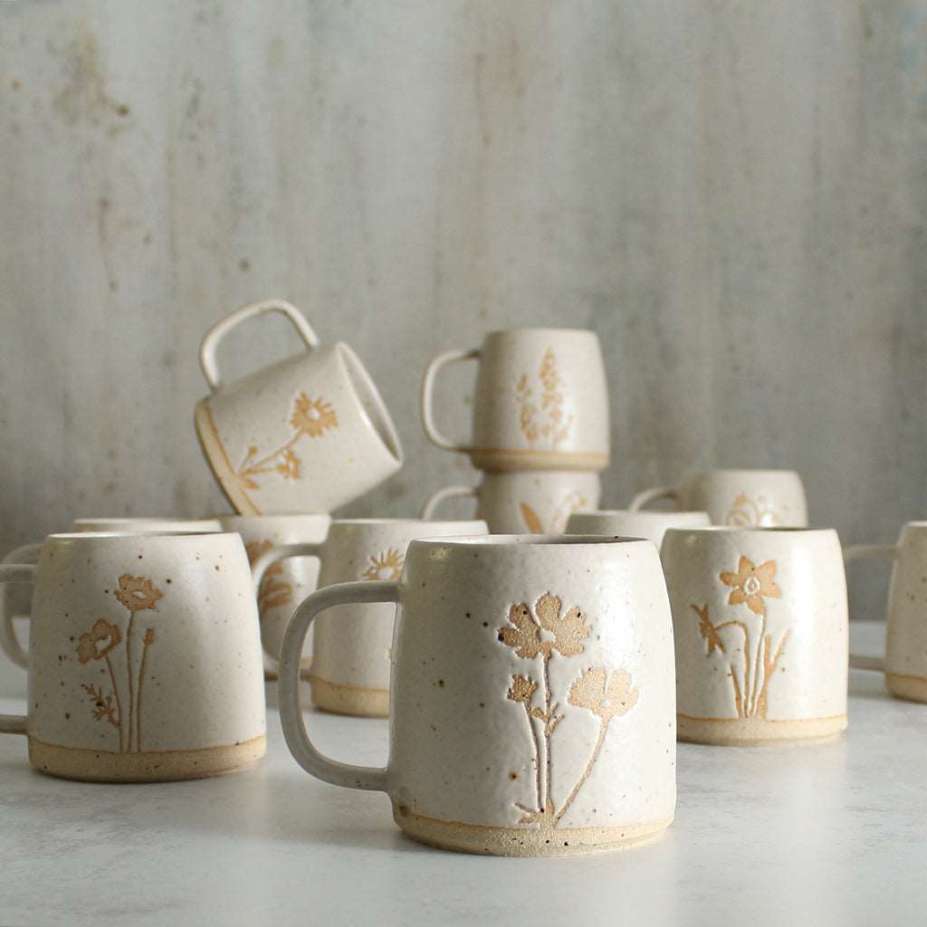 Close up of Cosmos birth flower mug with other mugs behind