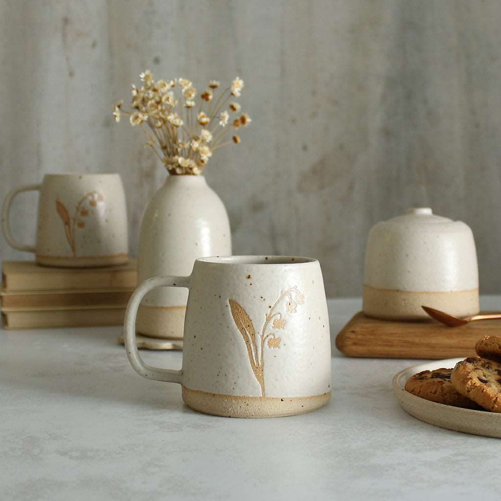 Lily of the Valley mug in front of white ceramics table setting