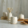 Snowdrop mug in front of white ceramics table setting