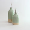 Small and large green stoneware oil pourers