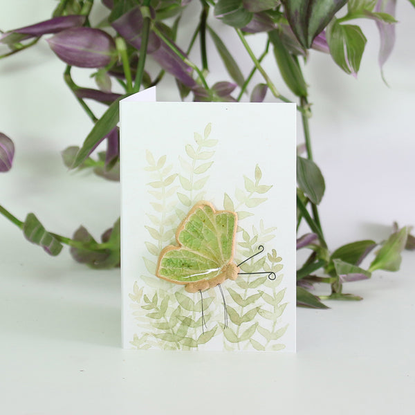 small ceramic and glass green butterfly on gift card with watercolour leaves