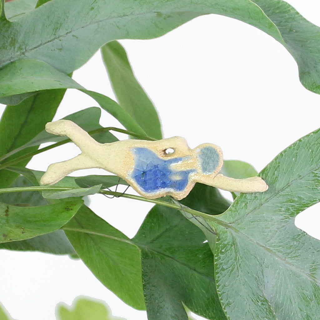 ceramic swimmer in dark blue glass swimsuit on plant stem