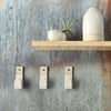 3 white stoneware wall hooks with white decor