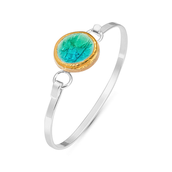 Side view of turquoise emerald gradient lagoon crackled glass round charm outlined in gold lustre on a silver plated latch bangle