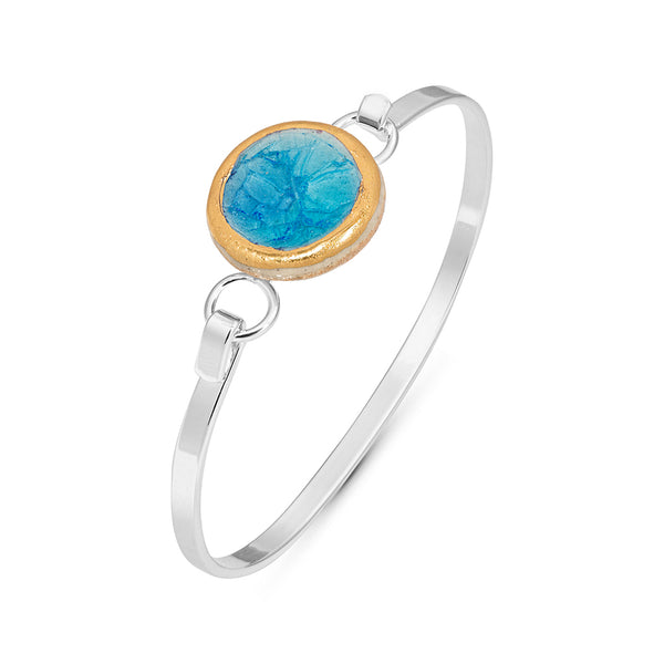 Side view of turquoise blue gradient lagoon crackled glass round charm outlined in gold lustre on a silver plated latch bangle