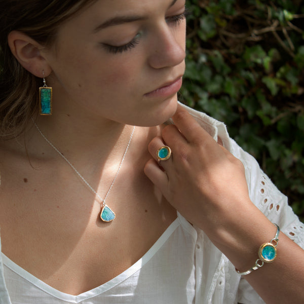 model wearing emerald turquoise glass and ceramic teardrop pendant, rings, bangle all with gold detailing - Habulous