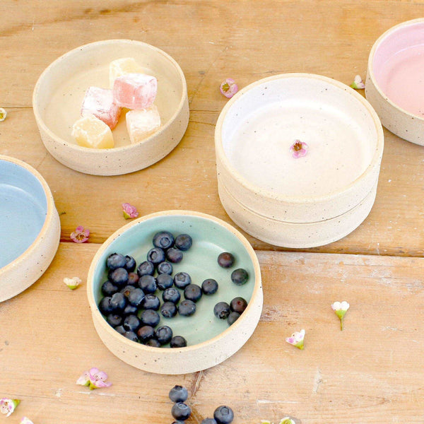 Varying stacks of pastel nibbles bowls with food