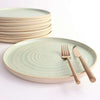 Mint Green dinner plate with copper cutlery next to stack of plates